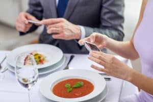 image of couple with cell phones at dinner